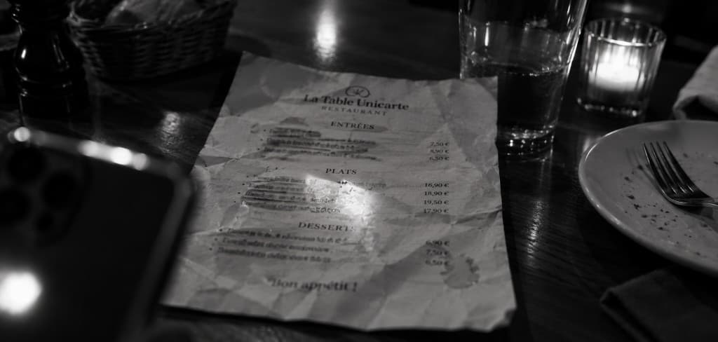 Menu papier froissé, taché, posé sur une table de restaurant
